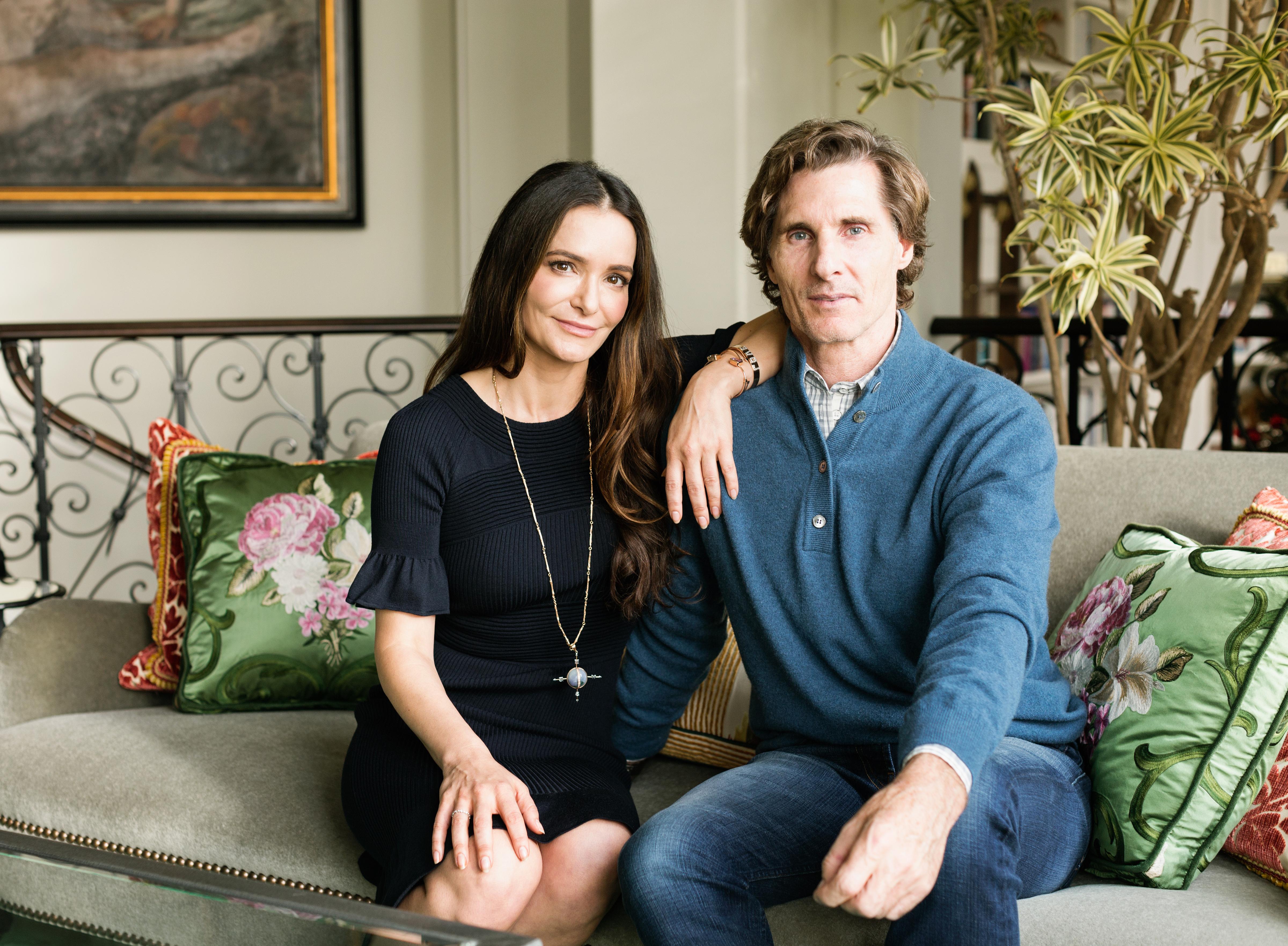 Mark and Tammy Strome sitting on a couch. His hand on her knee. Her arm draped over his shoulder.