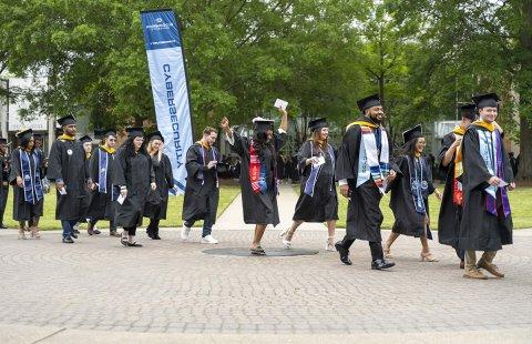 Graduation candidates carry on the tradition of crossing the University seal on their procession to S.B. Ballard Stadium for ODU’s 140th commencement exercises. 