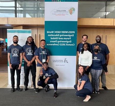 Students pose near poster